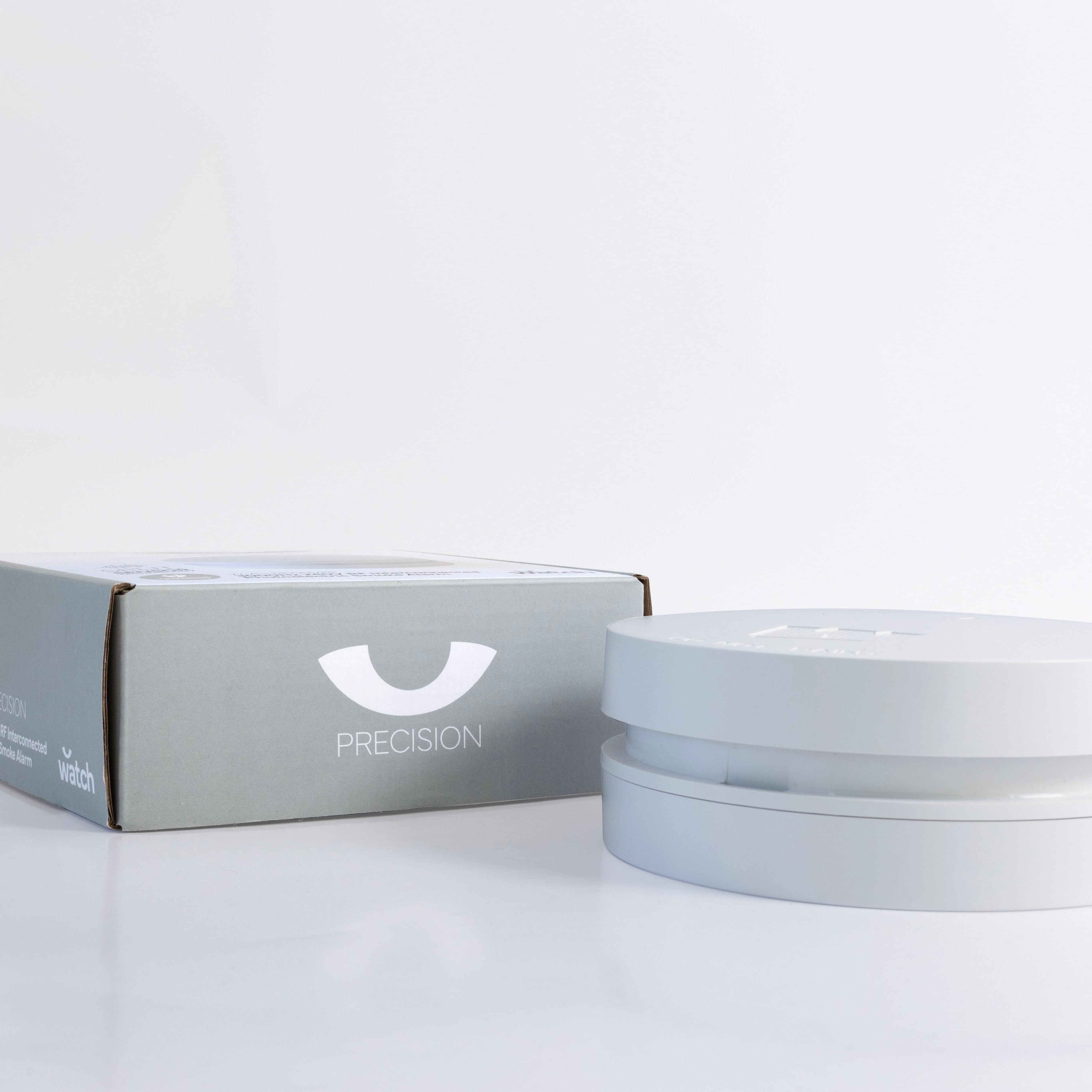 White smoke alarm and box with 'PRECISION' branding on a white background
